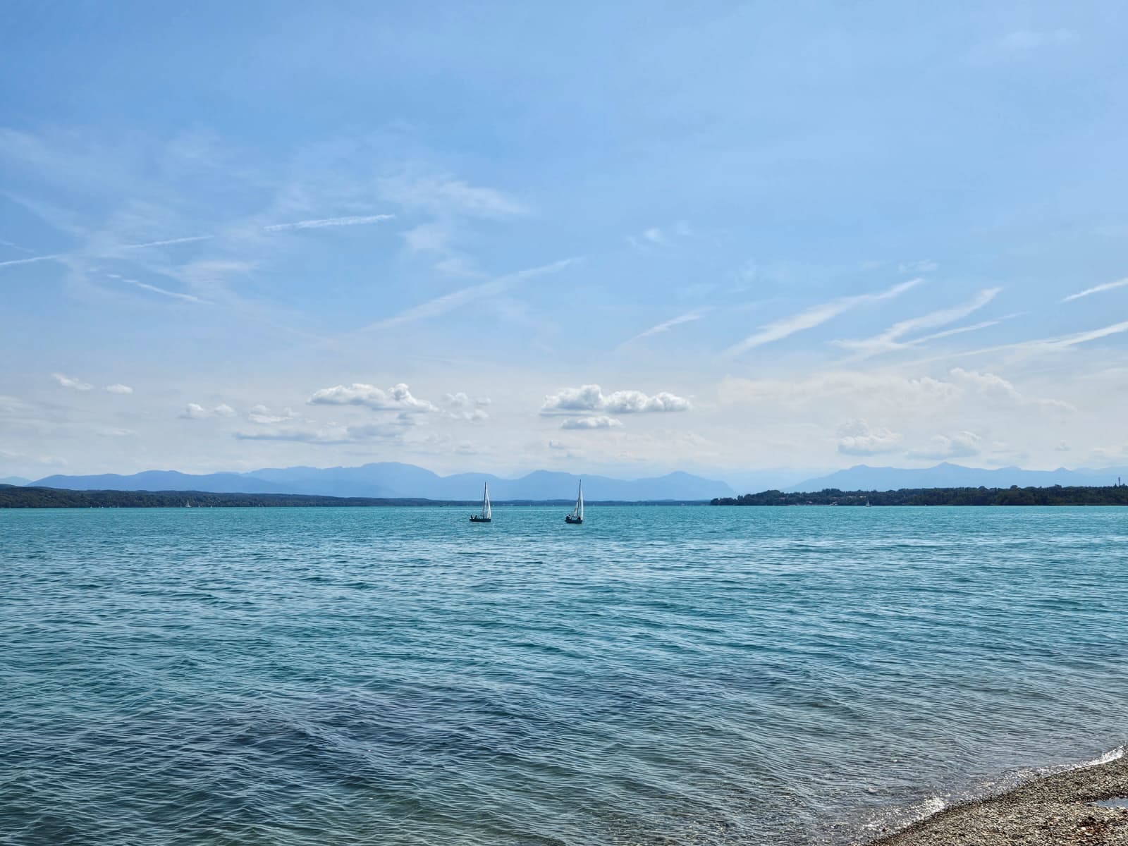 Weiter Blick über den Starnberger See mit Segelbooten und Alpenkette